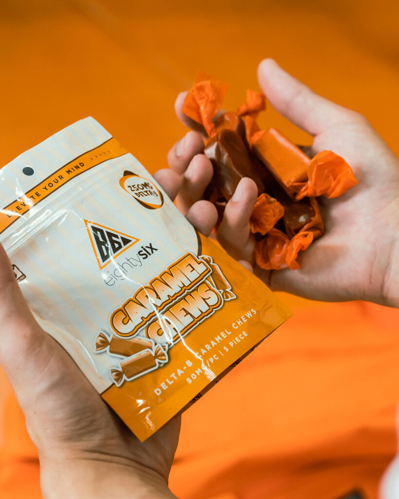 Guy holding the Delta-8 Caramel Chews bag and the individual pieces.