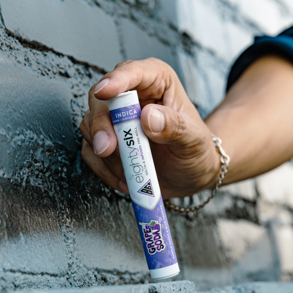 A man showing eighty six brand pre-roll grape soda