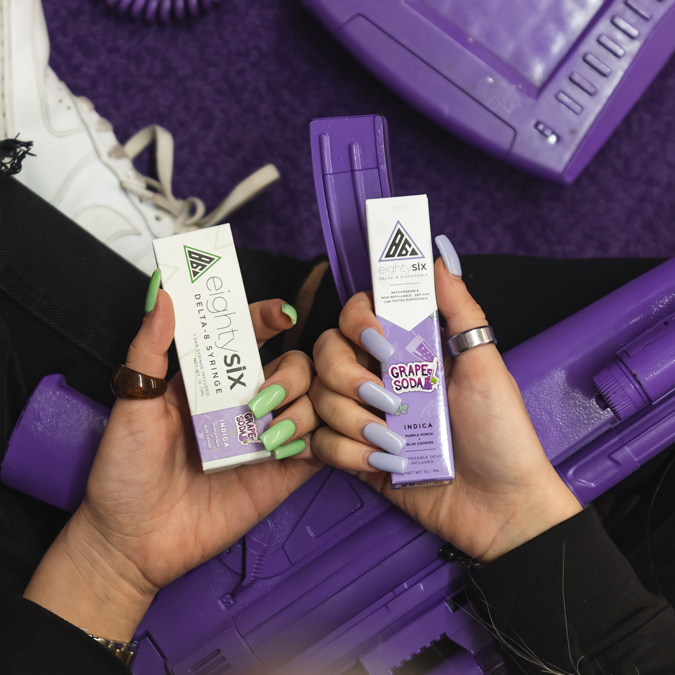 A woman holding delta 8 grape flavoored product