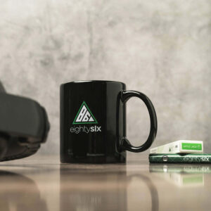 Black mug with a eighty six logo on it